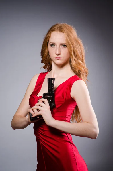 Girl in red dress with handgun — Stock Photo, Image