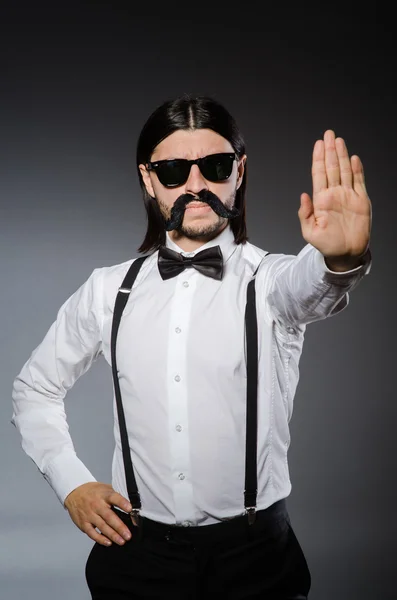 Homme avec moustache et lunettes de soleil contre gris — Photo