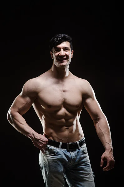 Uomo muscolare in posa in studio scuro — Foto Stock