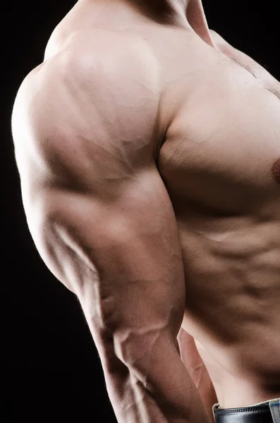 Hombre musculoso posando en estudio oscuro — Foto de Stock