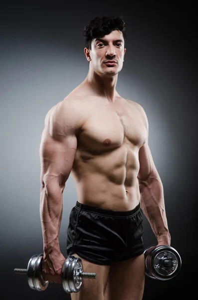 Muscular fisiculturista rasgado com halteres — Fotografia de Stock