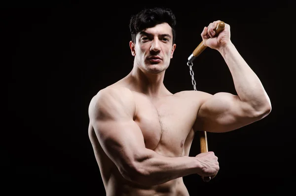 Muscular homem forte com nunchucks — Fotografia de Stock