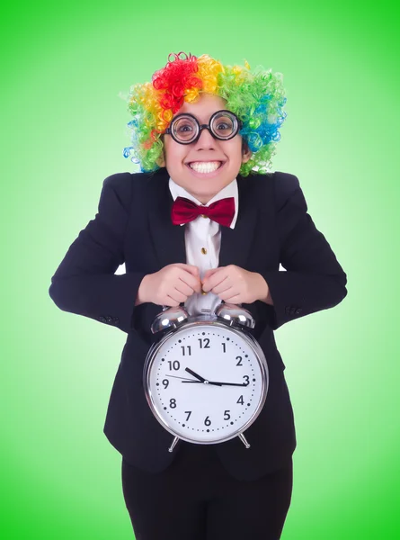 Grappige clown met klok op groen — Stockfoto