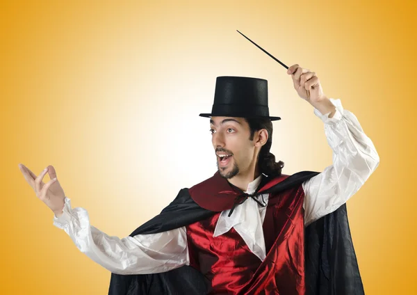 Magician doing tricks on yellow — Stock Photo, Image