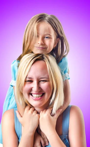 Szczęśliwa mama i córka na fioletowy — Zdjęcie stockowe