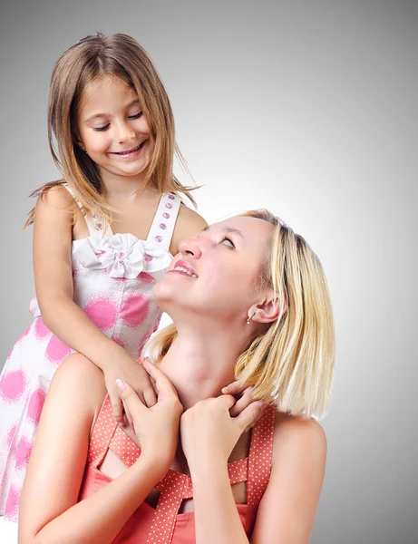 Happy mom and daughter on grey — Stock Photo, Image