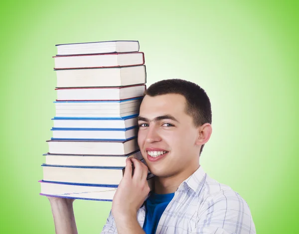 Student with lots of books on green — Stock Photo, Image