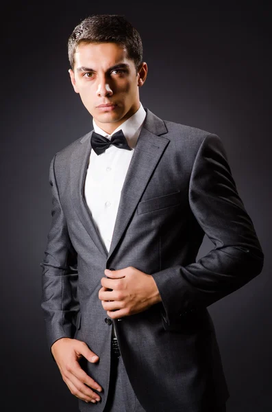 Jovem homem elegante contra cinza — Fotografia de Stock