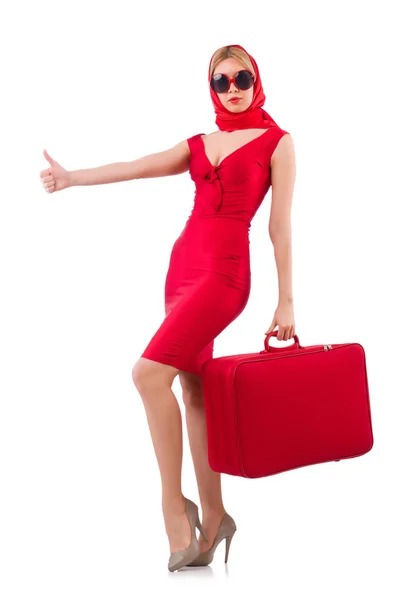 Blondine im roten Kleid mit Koffer auf weißem Hintergrund — Stockfoto