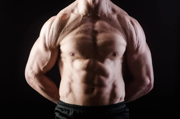 Homem muscular posando em estúdio escuro — Fotografia de Stock