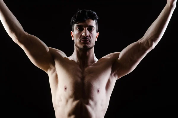 Musclé homme posant dans sombre studio — Photo