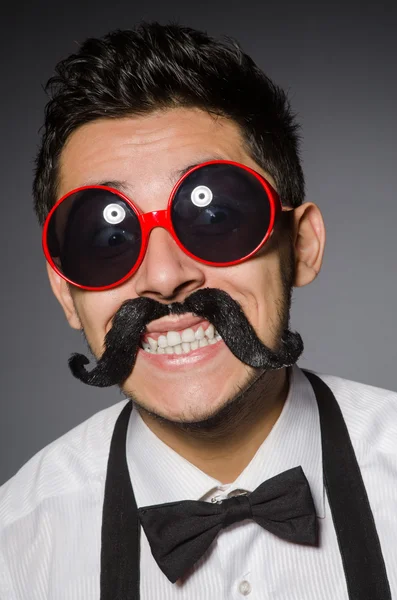 Joven hombre caucásico usando gafas de sol contra gris — Foto de Stock