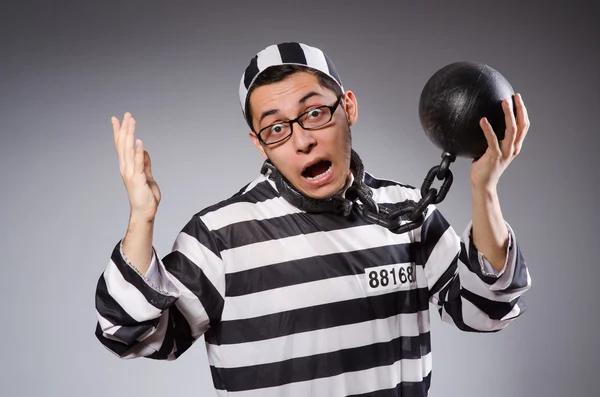 Young prisoner in chains against gray — Stock Photo, Image