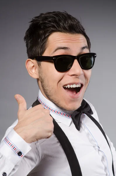 Smiling man in sunglasses against gray — Stock Photo, Image