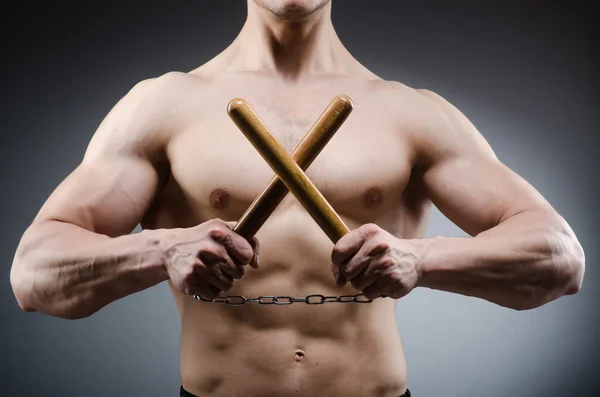 Musclé homme fort avec des nunchakus — Photo