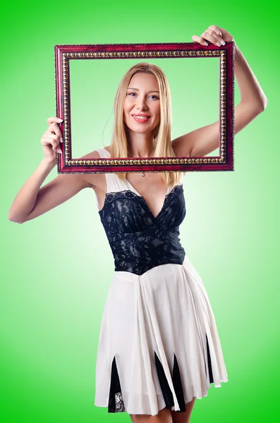 Young woman with picture frame on white — Stock Photo, Image