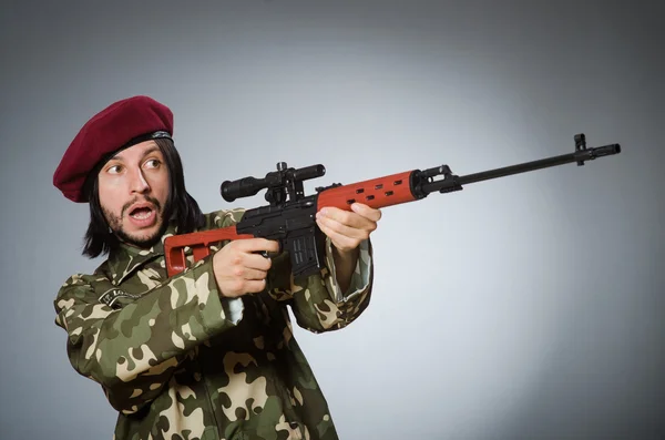 Soldado com pistola contra cinza — Fotografia de Stock