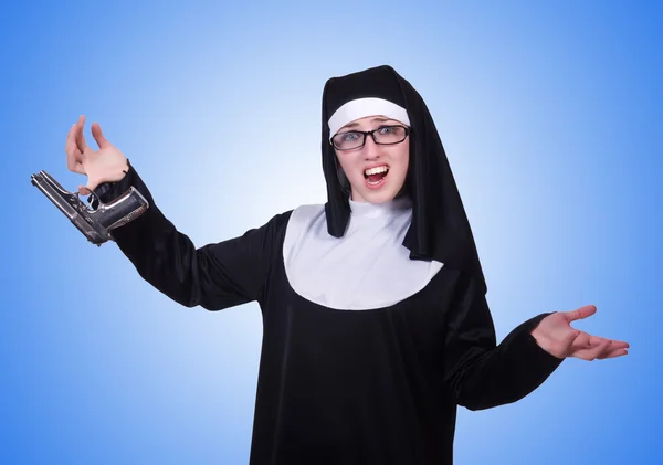 Nun with handgun isolated on blue — Stock Photo, Image