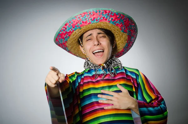 Man in vivid mexican poncho against gray