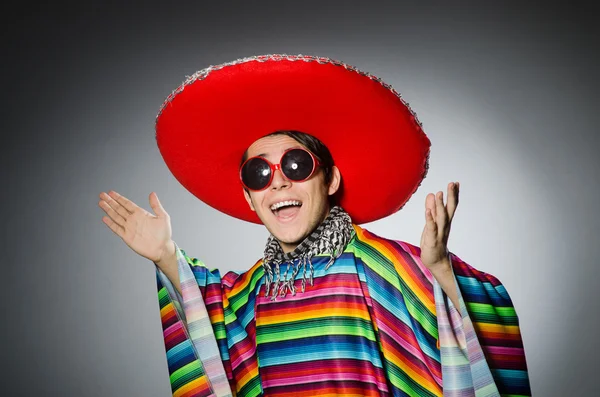 Hombre en poncho mexicano vívido contra gris — Foto de Stock