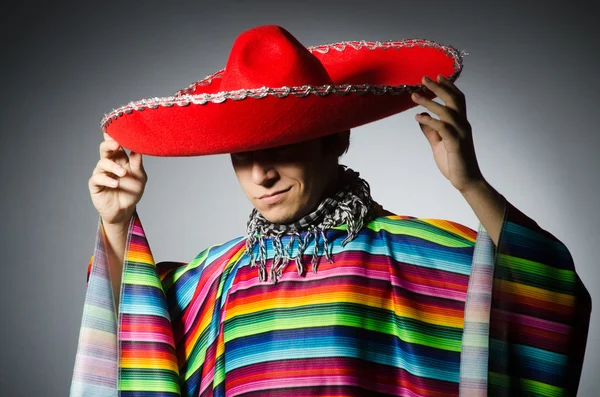 Hombre en poncho mexicano vívido contra gris — Foto de Stock