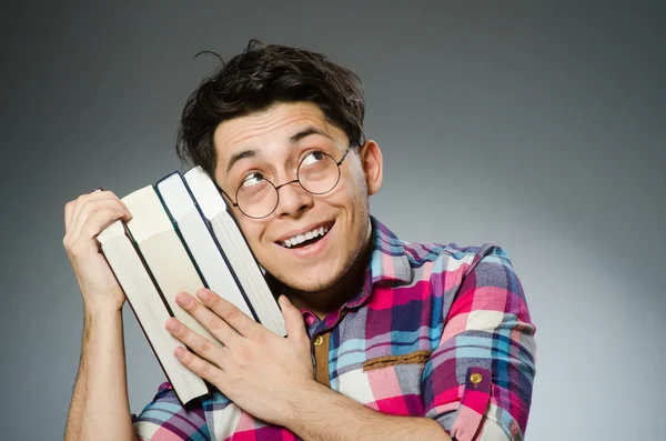 Смешной студент с большим количеством книг — стоковое фото