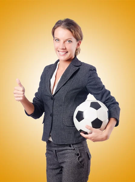 Businesswoman with football on yellow — Stock Photo, Image