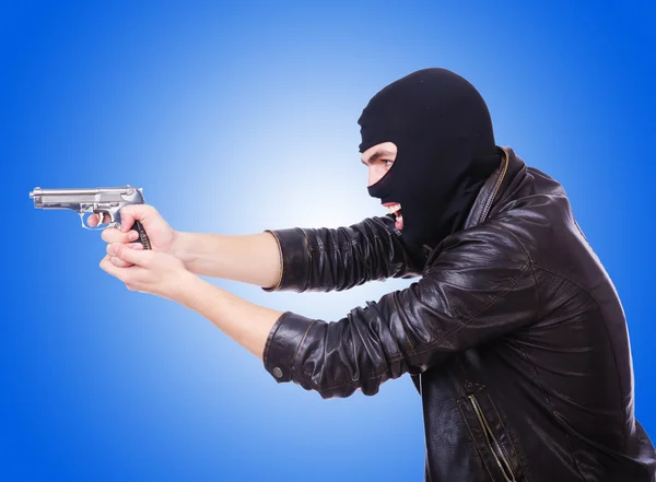 Young thug with gun isolated on blue — Stock Photo, Image