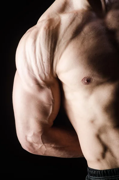 Homem muscular posando em estúdio escuro — Fotografia de Stock
