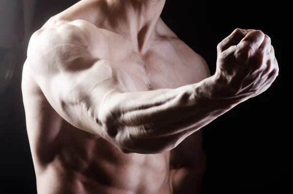 Hombre musculoso posando en estudio oscuro — Foto de Stock