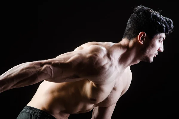 Homem muscular posando em estúdio escuro — Fotografia de Stock