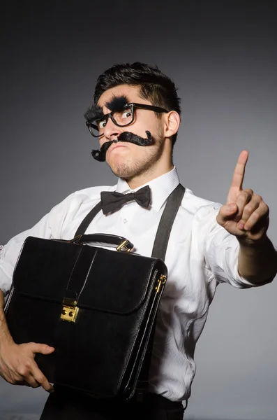 Young caucasian man with false moustache against gray — Stock Photo, Image