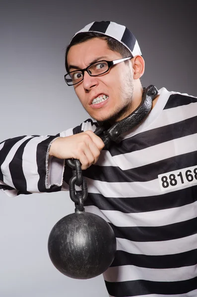 Young prisoner in chains against gray — Stock Photo, Image