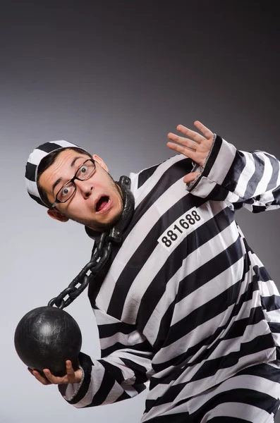 Young prisoner in chains against gray — Stock Photo, Image