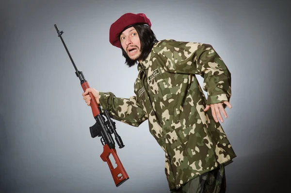 Soldat mit Handfeuerwaffe gegen Grau — Stockfoto