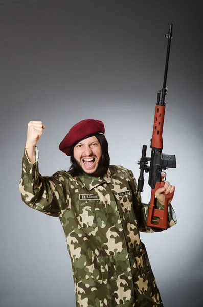 Soldado com pistola contra cinza — Fotografia de Stock