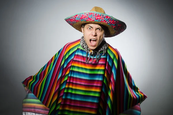 Hombre en poncho mexicano vívido contra gris — Foto de Stock