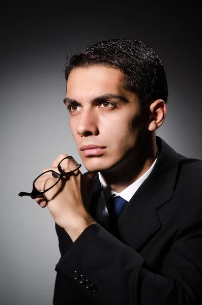 Young businessman in dark studio — Stock Photo, Image