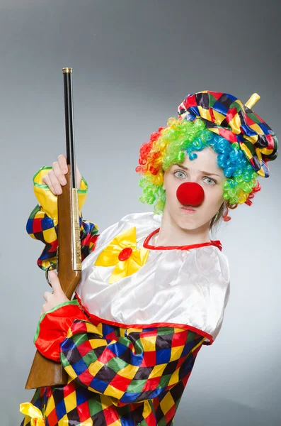 Clown met geweer geïsoleerd op grijs — Stockfoto