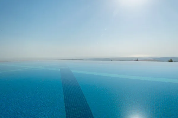 Piscina infinita en el brillante día de verano — Foto de Stock