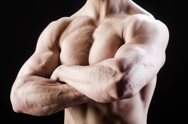 Hombre musculoso posando en estudio oscuro — Foto de Stock