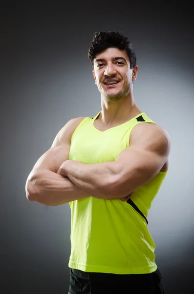 Muscular man posing in dark studio — Stock Photo, Image