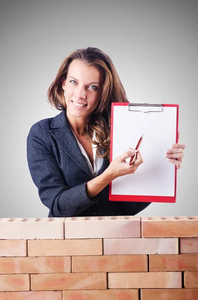 Femme constructeur et mur de briques — Photo