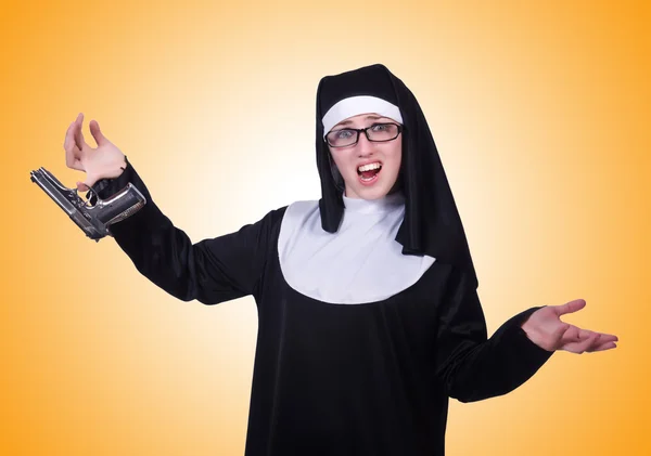 Nun with handgun isolated on yellow — Stock Photo, Image