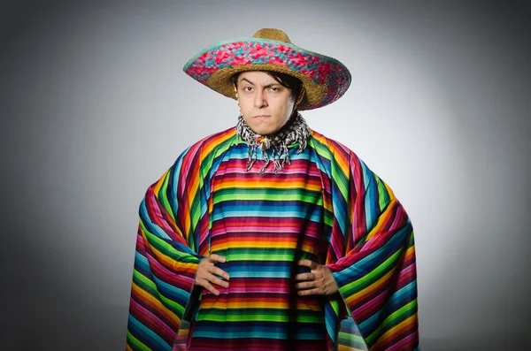 Hombre en poncho mexicano vívido contra gris — Foto de Stock