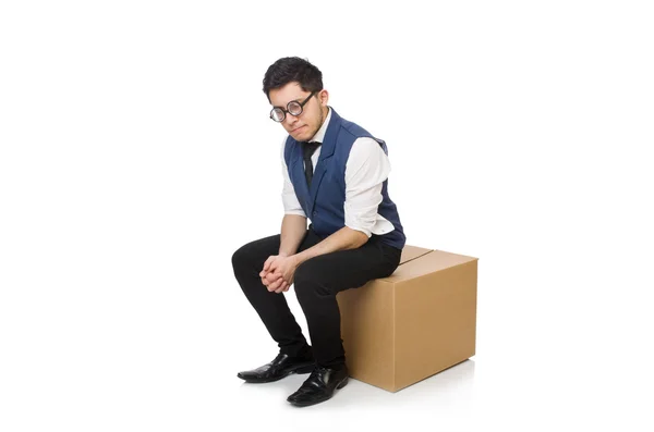 Młody pracownik siedzi na pudełku odizolowany na biało — Zdjęcie stockowe