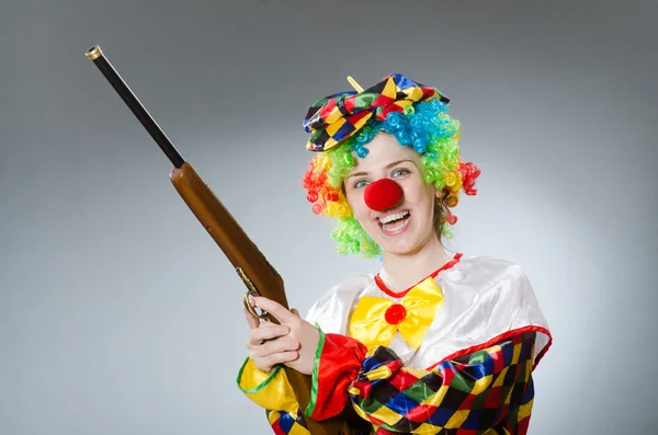Клоун з гвинтівкою ізольовано на сірому — стокове фото