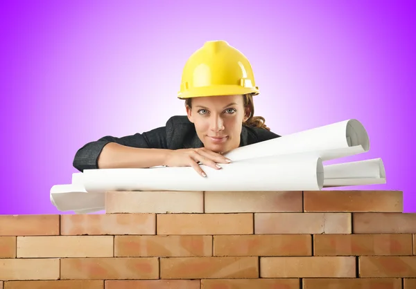 Zakenvrouw met tekeningen in de buurt van bakstenen muur — Stockfoto