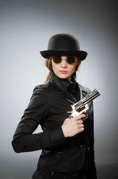 Žena špion se zbraní proti šedé — Stock fotografie
