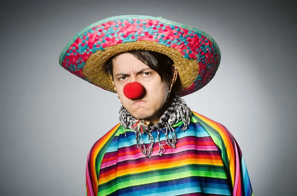 Hombre en poncho mexicano vívido contra gris — Foto de Stock